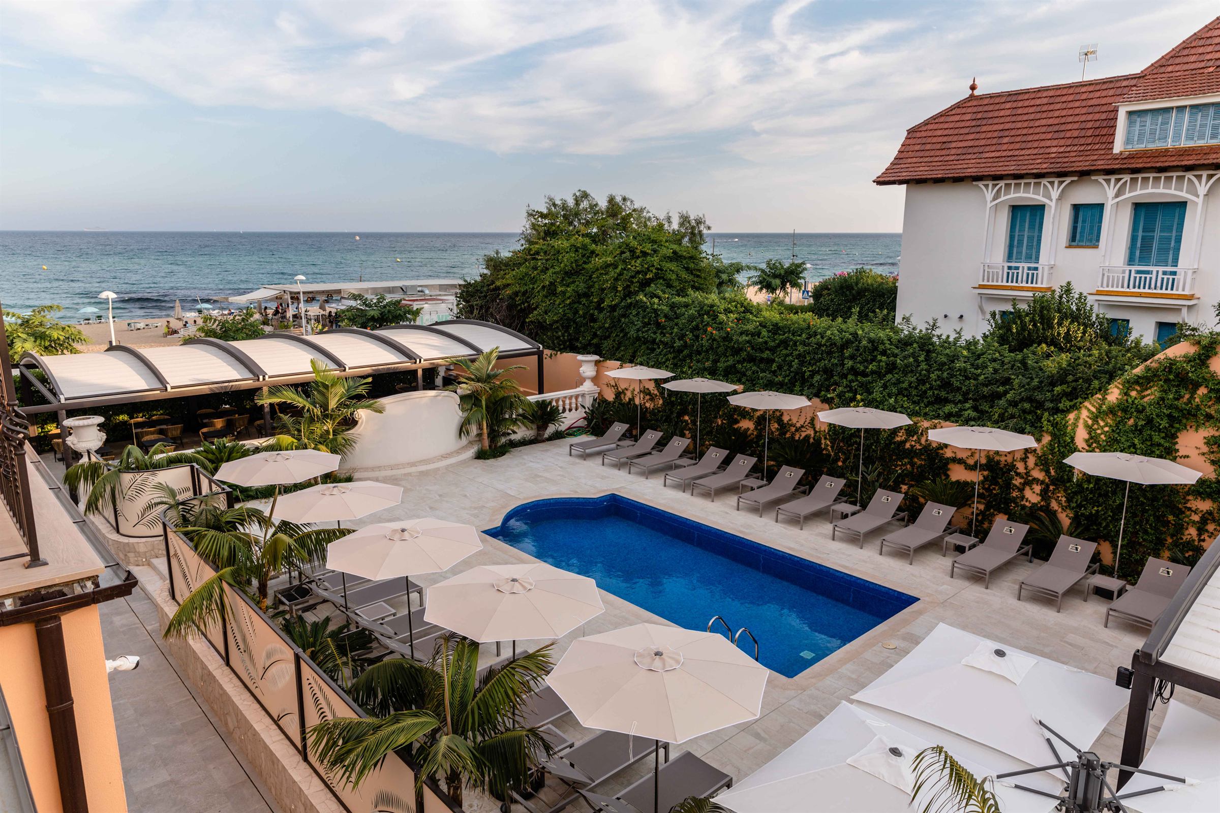 The hotel pool and sun terrace looking out over the beach and the Mediterranean